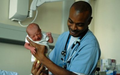 A doctor holding a baby