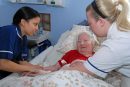 Two nurses caring for an older woman