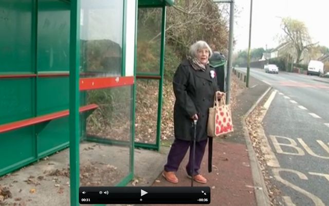 An older lady at a bus stop
