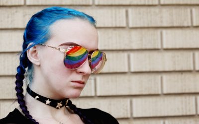 A woman with blue hair and sunglasses