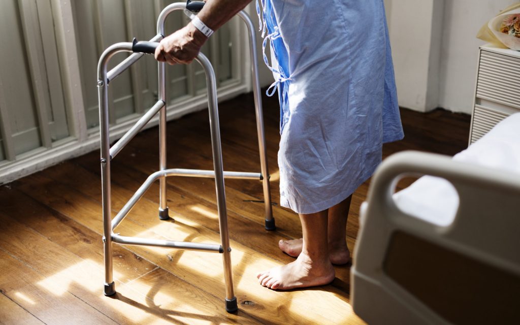 An older person with a walking frame