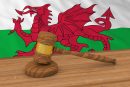 A gavel in front of a welsh flag