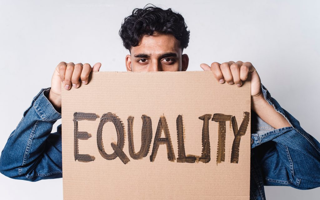 A man holding a sign saying equality