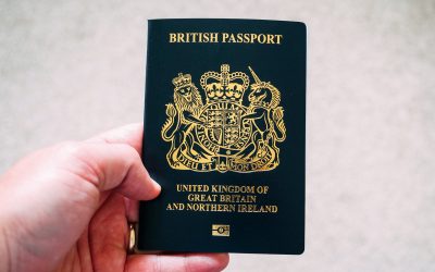 A hand holding a blue passport