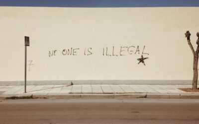Graffiti saying no-one is illegal on a white wall