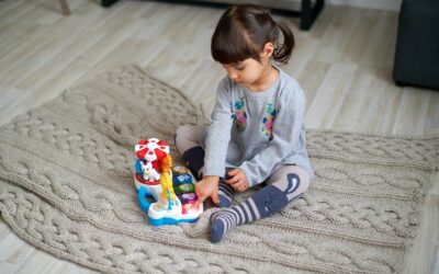 Girl in Gray Sweater Playing With Plastic Toy